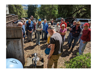 man measures well while group watches him