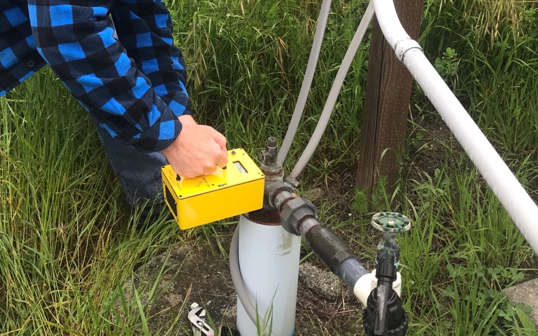 photo of two hands using a groundwater monitoring tool